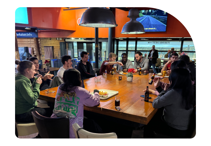 A group of Beatgrid team members gathered around a large table, enjoying dinner and engaging in lively conversation at a cozy indoor setting.