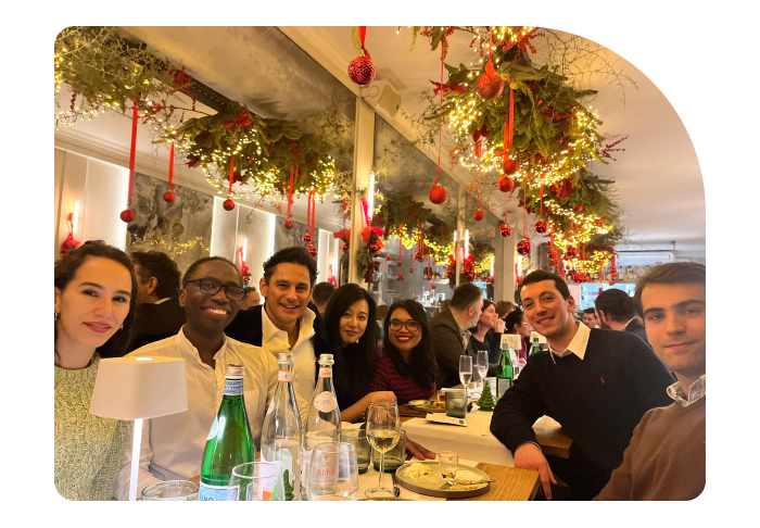 Beatgrid team members smiling and enjoying a festive Christmas dinner, surrounded by holiday decorations.